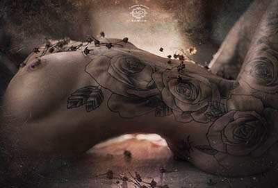 photo de femme nue tattouée avec roses et lumière