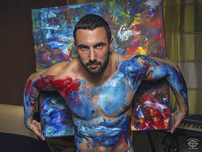 photo d'homme musclé aevec peinture sur le corps et toile peinte
