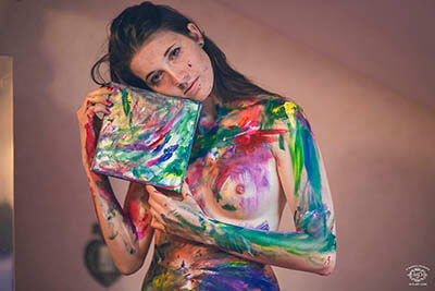 belle jeune femme peinture sur corps tenant une toile colorée