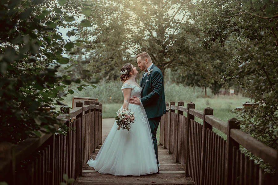 photo de couple de mariés avec voiture vintage dans un parc